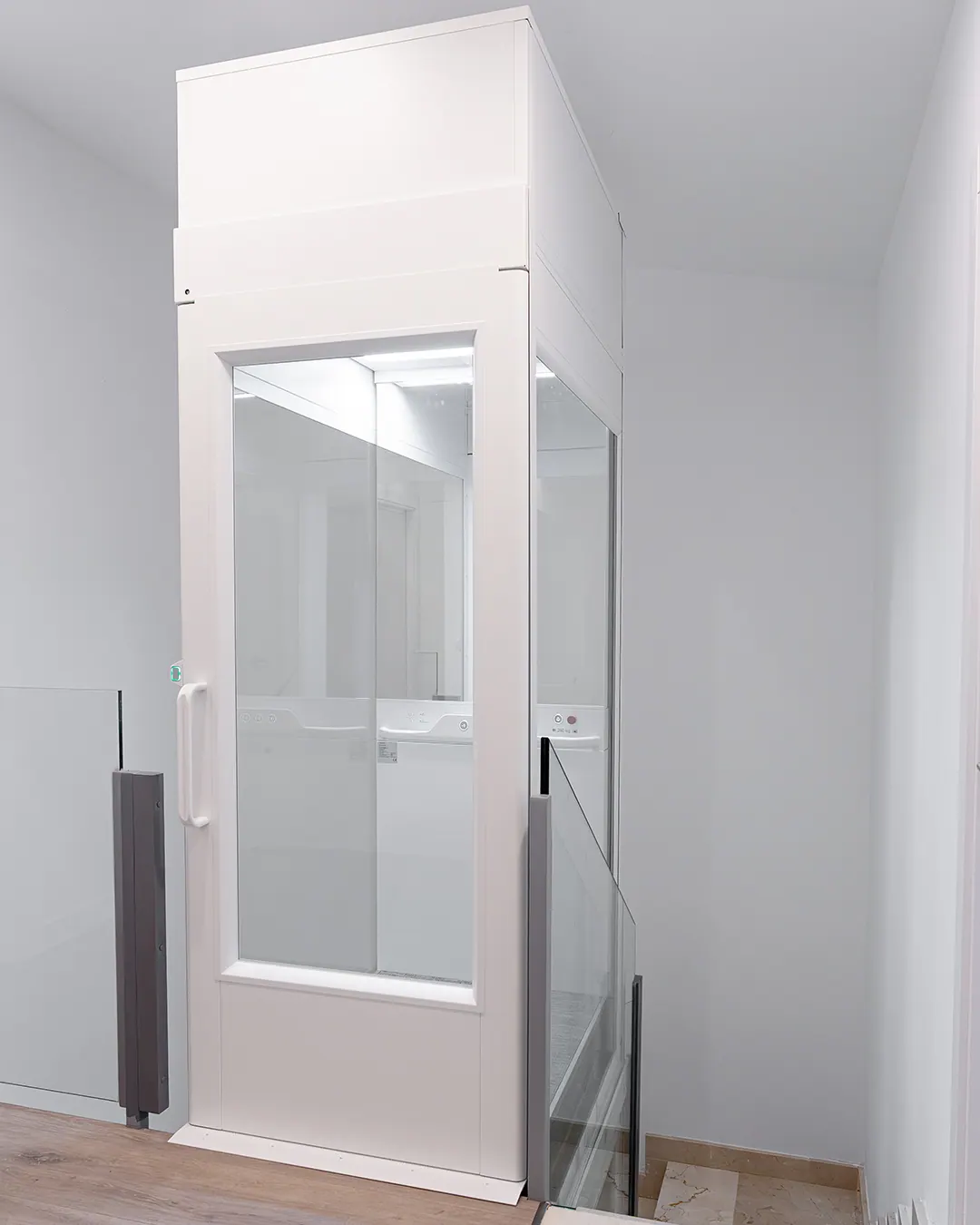 Ascensor Aritco HomeLift Compact de cristal en blanco · Vivienda unifamiliar con escalera de mármol en Boadilla del Monte · vista general