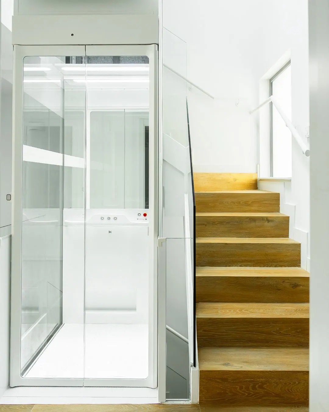Ascensor Aritco HomeLift Compact de cristal en blanco · Vivienda unifamiliar con escalera de madera en Boadilla del Monte · vista general