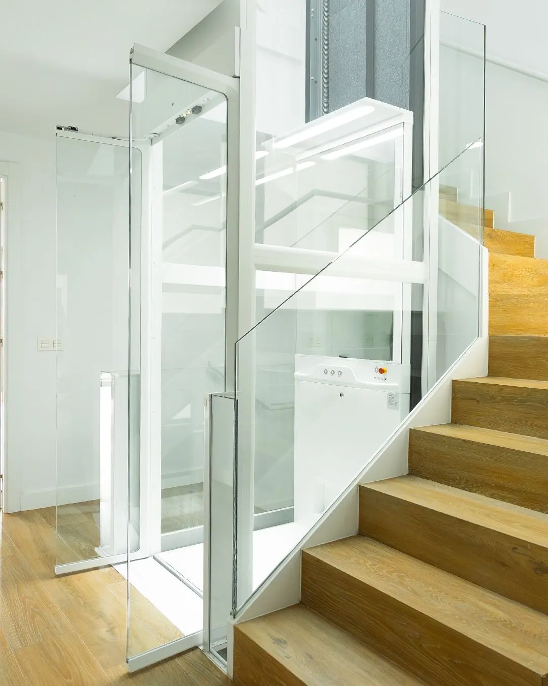 Ascensor Aritco HomeLift Compact de cristal en blanco · Vivienda unifamiliar con escalera de madera en Boadilla del Monte · vista general
