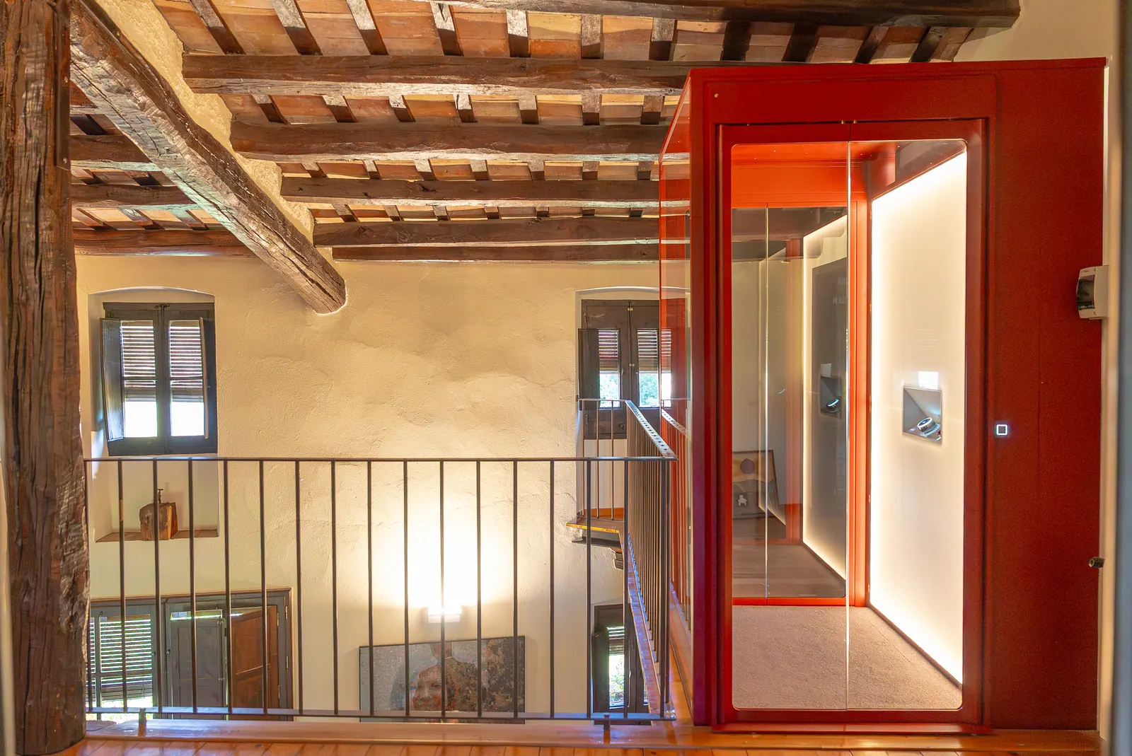 Ascensor Aritco HomeLift de cristal y paneles en rojo · Masía en Girona · vista general