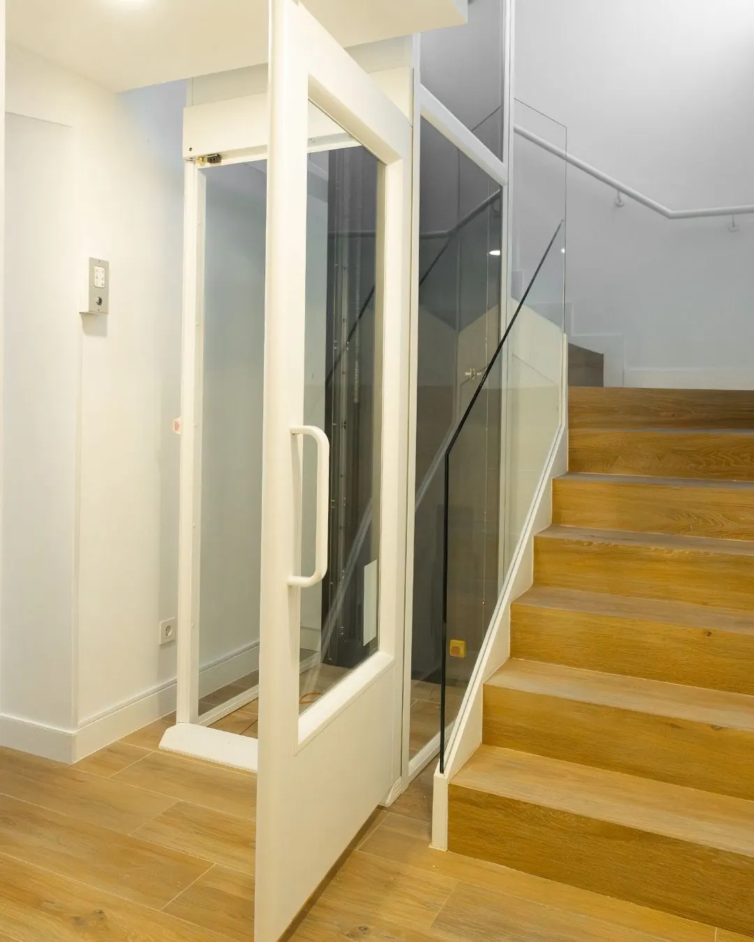 Ascensor Aritco HomeLift Compact de cristal en blanco · Vivienda unifamiliar con escalera de madera en Boadilla del Monte · vista general