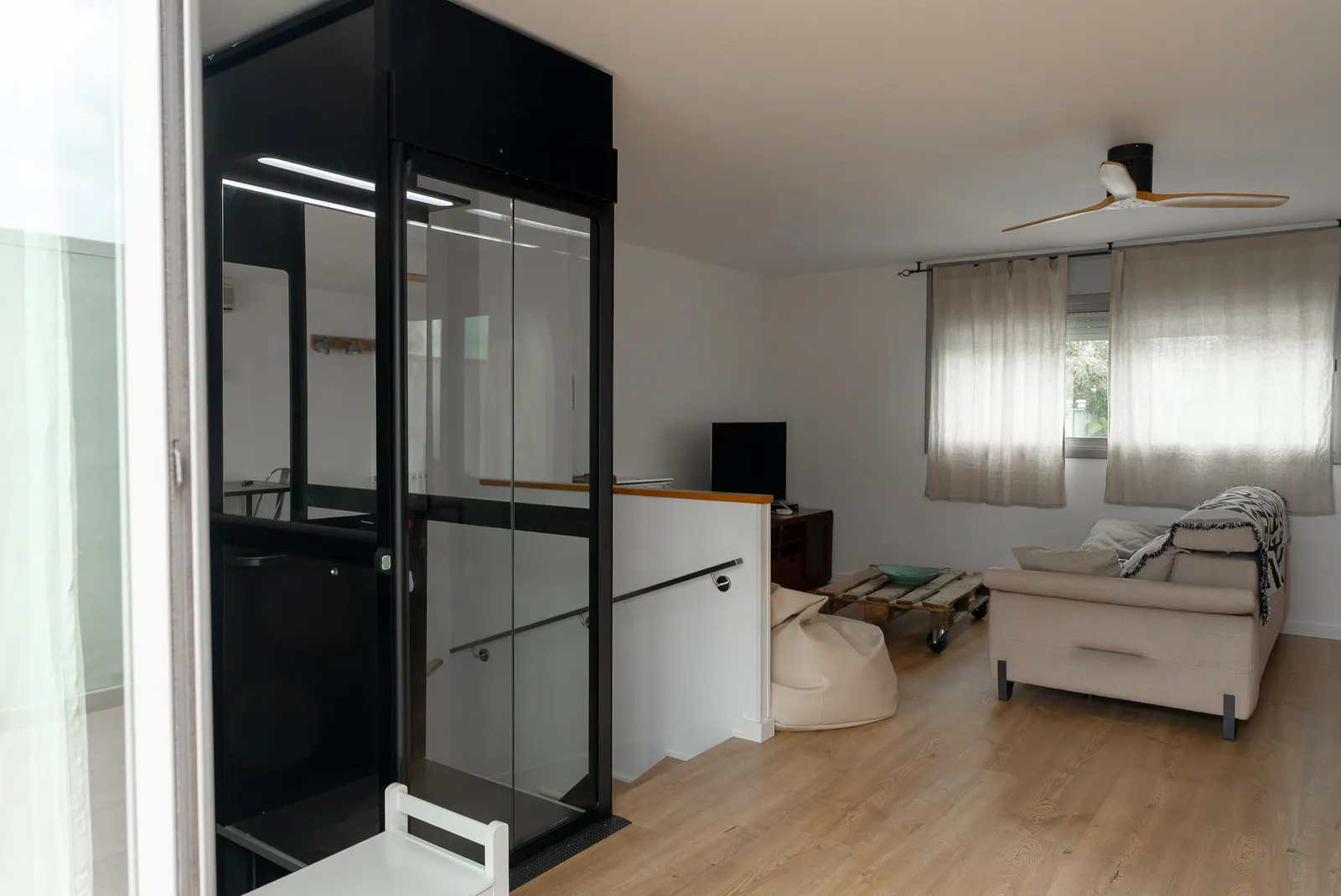 Ascensor Aritco HomeLift Compact de cristal en negro · Vivienda unifamiliar en Sabadell con ascensor junto a la chimenea · vista general