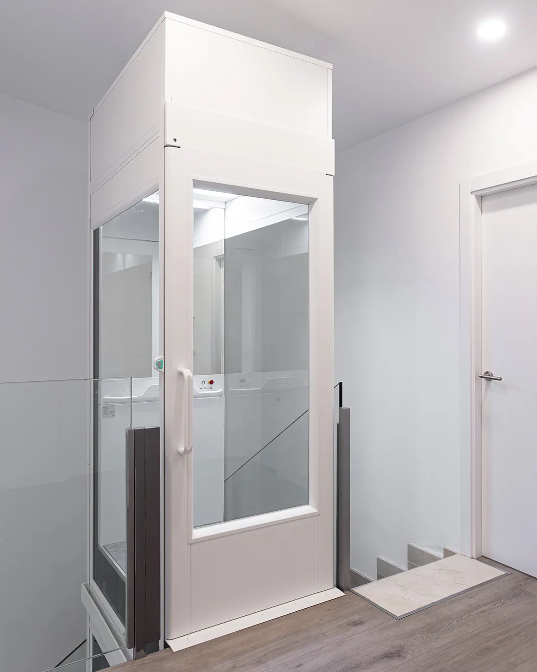 Ascensor Aritco HomeLift Compact de cristal en blanco · Vivienda unifamiliar con escalera de mármol en Boadilla del Monte · vista general