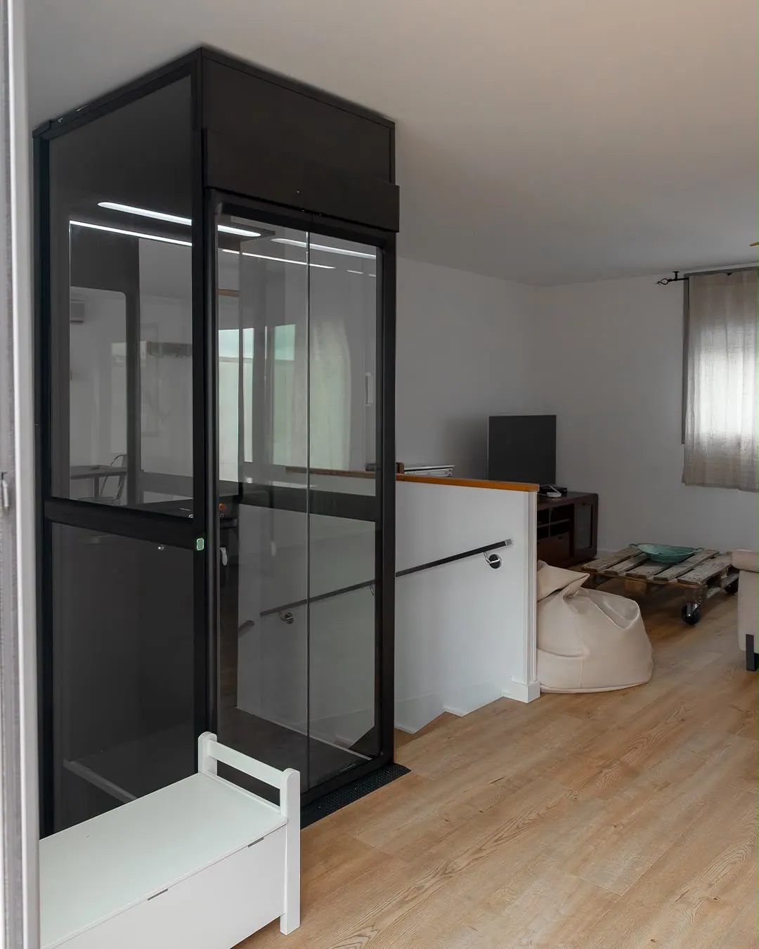 Ascensor Aritco HomeLift Compact de cristal en negro · Vivienda unifamiliar en Sabadell con ascensor junto a la chimenea · vista general