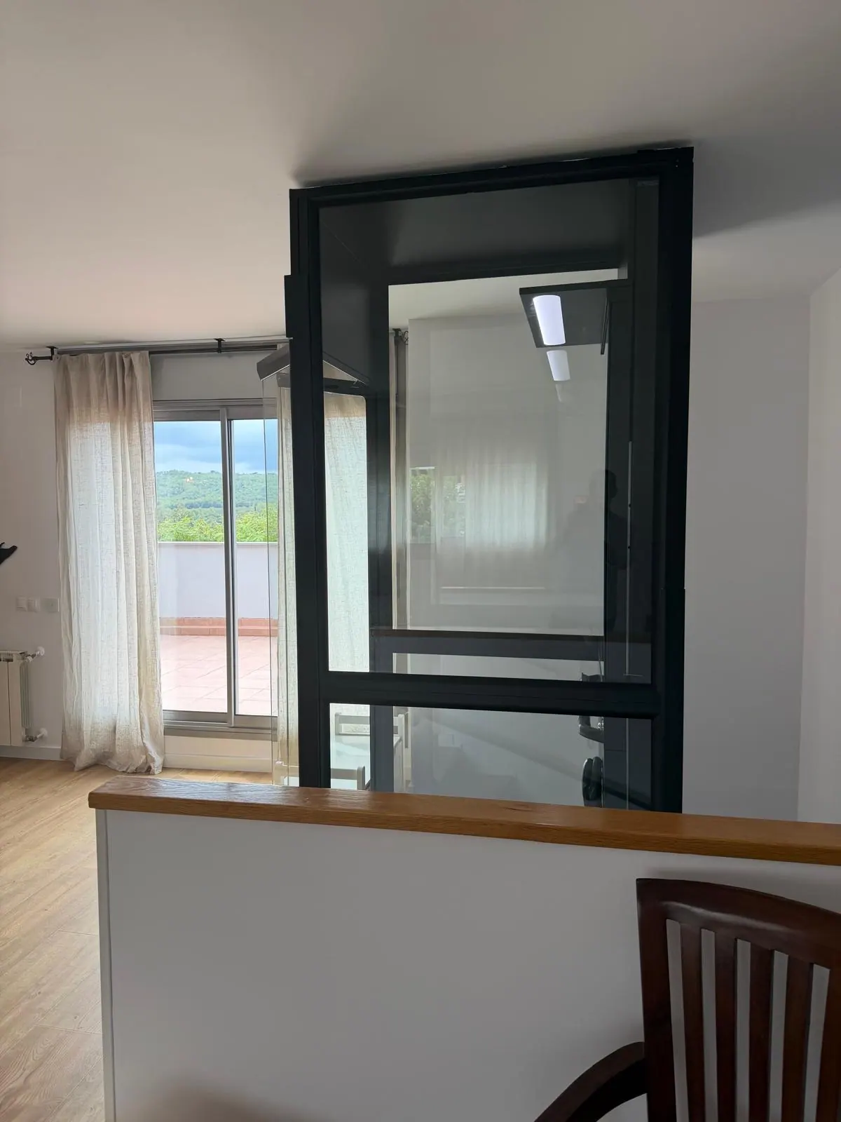Ascensor Aritco HomeLift Compact de cristal en negro · Vivienda unifamiliar en Sabadell con ascensor junto a la chimenea · vista general