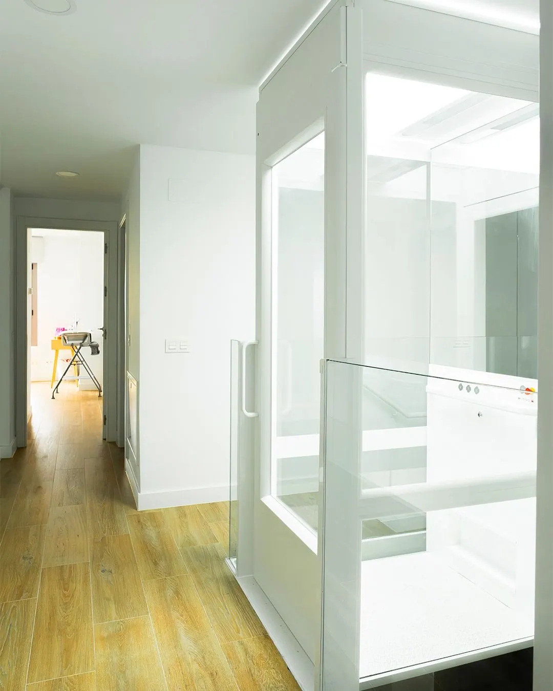 Ascensor Aritco HomeLift Compact de cristal en blanco · Vivienda unifamiliar con escalera de madera en Boadilla del Monte · vista general