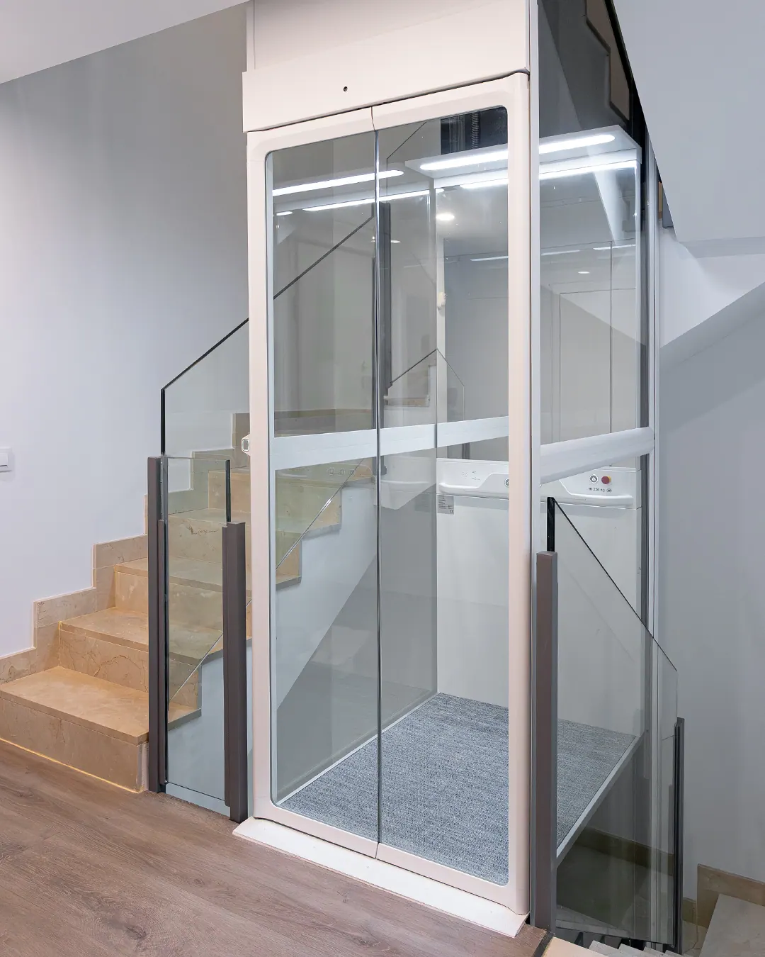 Ascensor Aritco HomeLift Compact de cristal en blanco · Vivienda unifamiliar con escalera de mármol en Boadilla del Monte · vista general