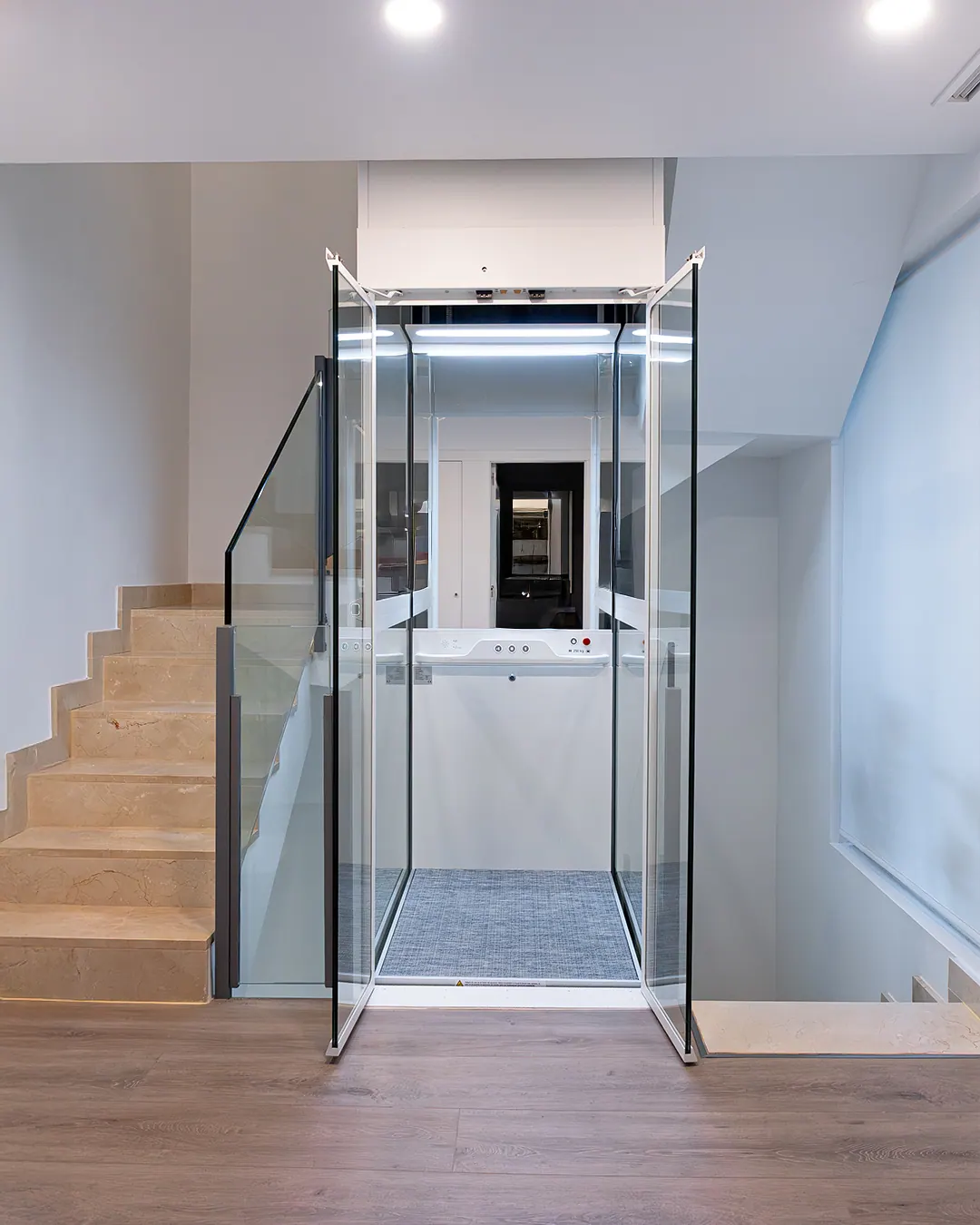 Ascensor Aritco HomeLift Compact de cristal en blanco · Vivienda unifamiliar con escalera de mármol en Boadilla del Monte · vista general