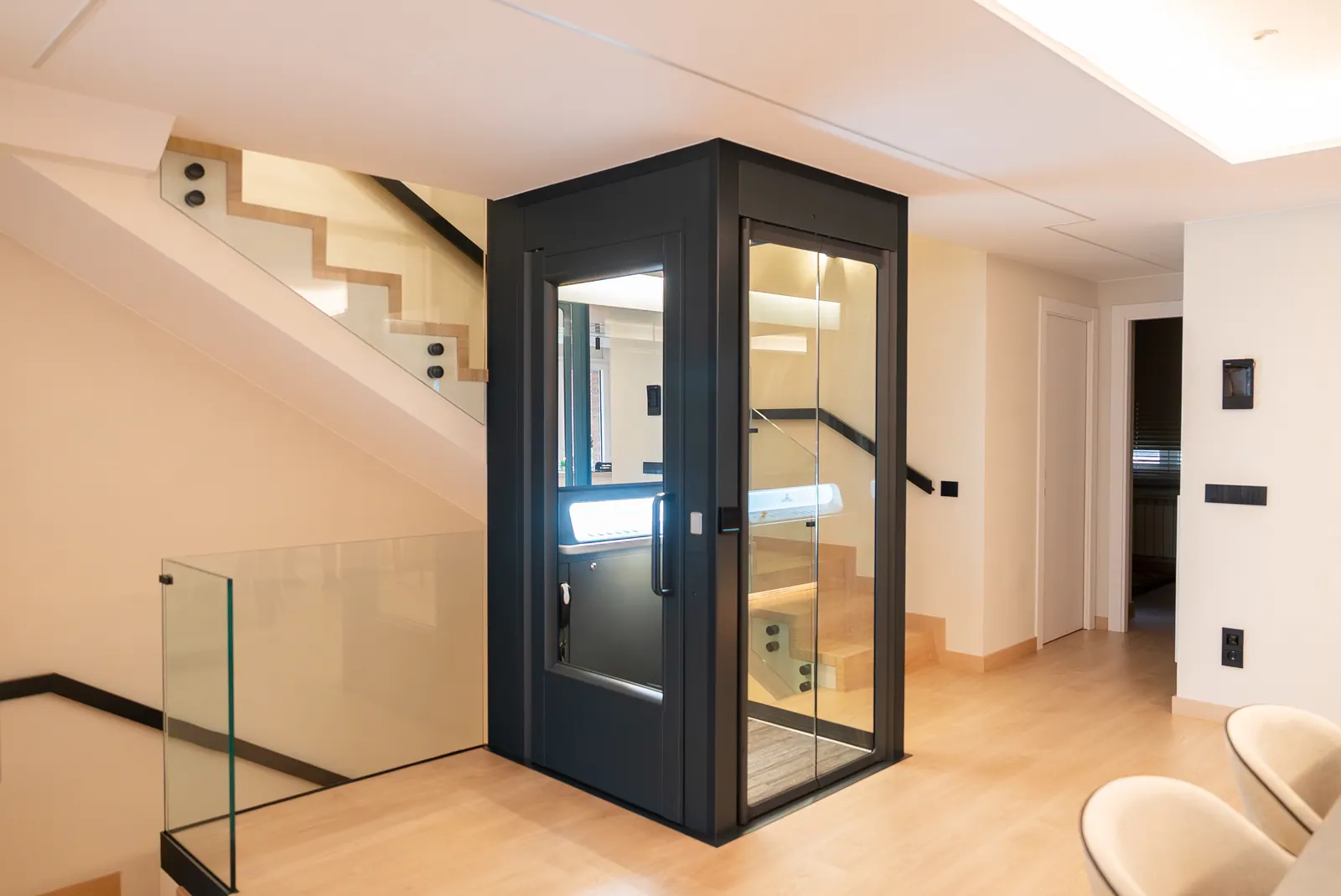 Ascensor Aritco HomeLift Access de cristal y paneles en antracita · Vivienda unifamiliar en Sabadell con escalera de madera · vista general