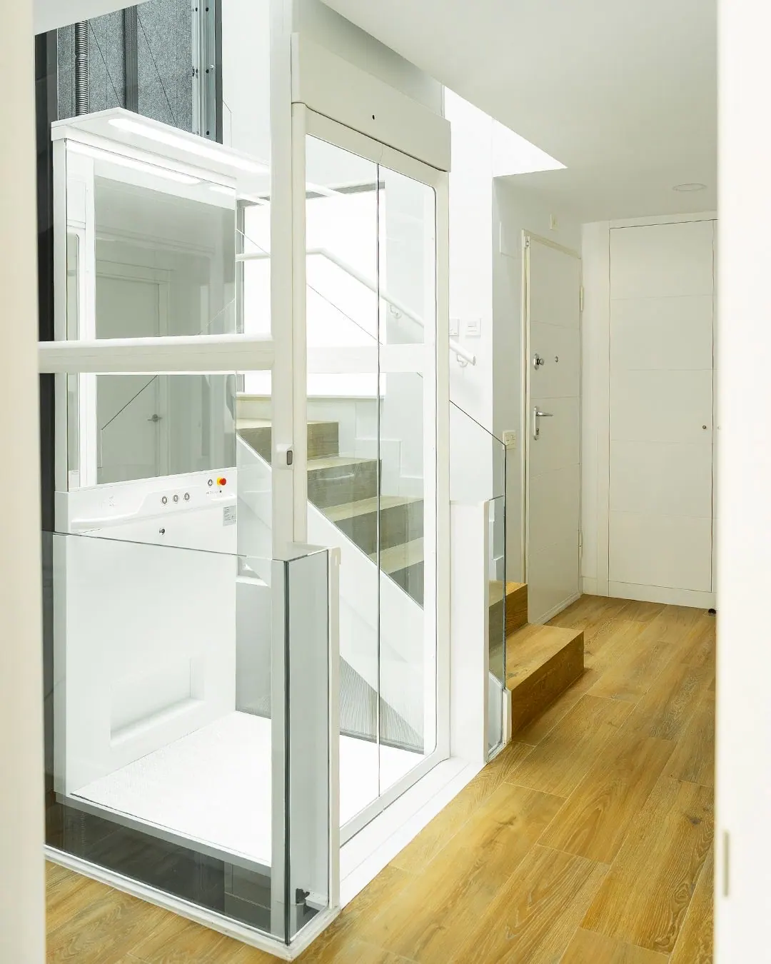 Ascensor Aritco HomeLift Compact de cristal en blanco · Vivienda unifamiliar con escalera de madera en Boadilla del Monte · vista general