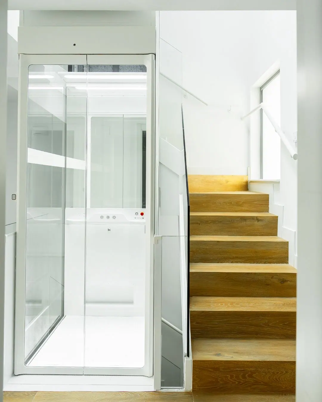 Ascensor Aritco HomeLift Compact de cristal en blanco · Vivienda unifamiliar con escalera de madera en Boadilla del Monte · vista general