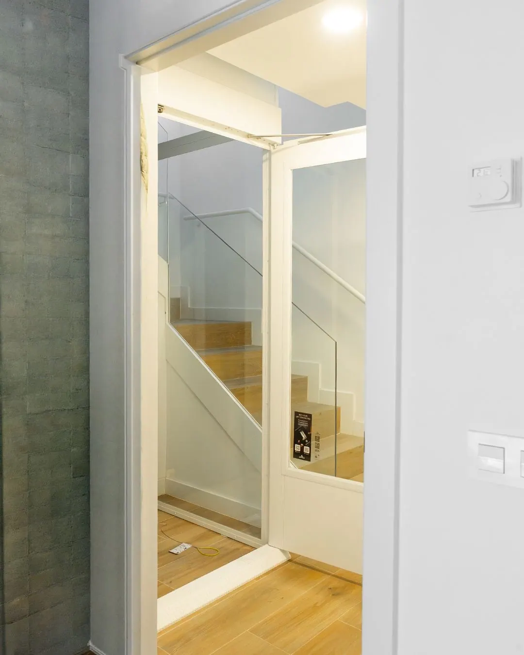 Ascensor Aritco HomeLift Compact de cristal en blanco · Vivienda unifamiliar con escalera de madera en Boadilla del Monte · vista general