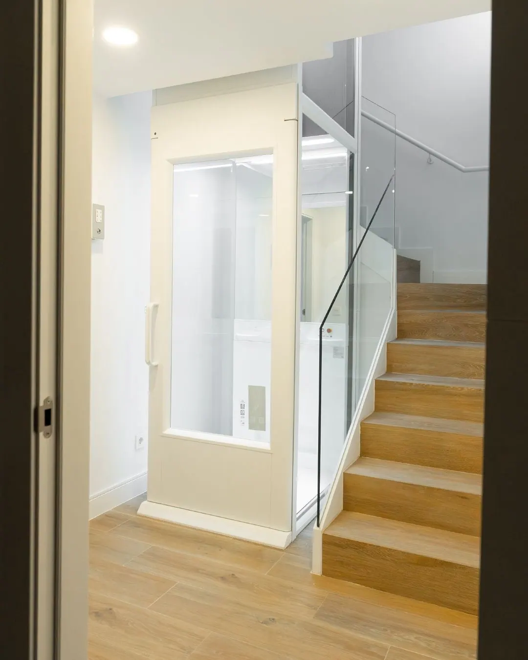 Ascensor Aritco HomeLift Compact de cristal en blanco · Vivienda unifamiliar con escalera de madera en Boadilla del Monte · vista general