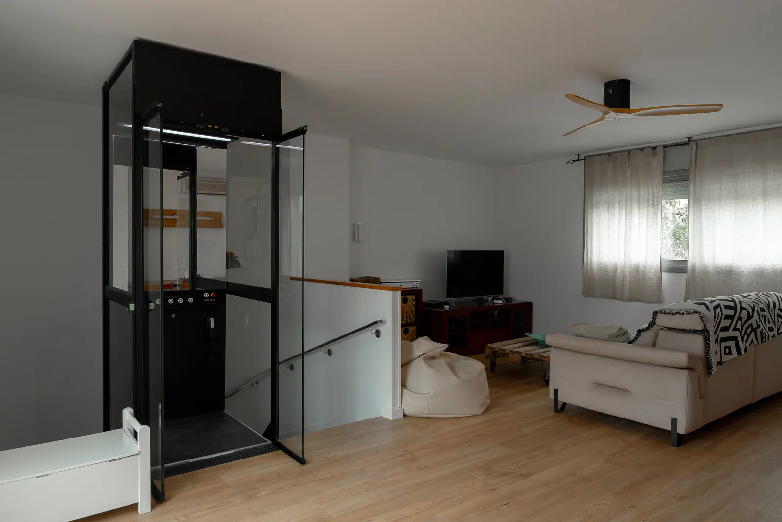 Ascensor Aritco HomeLift Compact de cristal en negro · Vivienda unifamiliar en Sabadell con ascensor junto a la chimenea · vista general