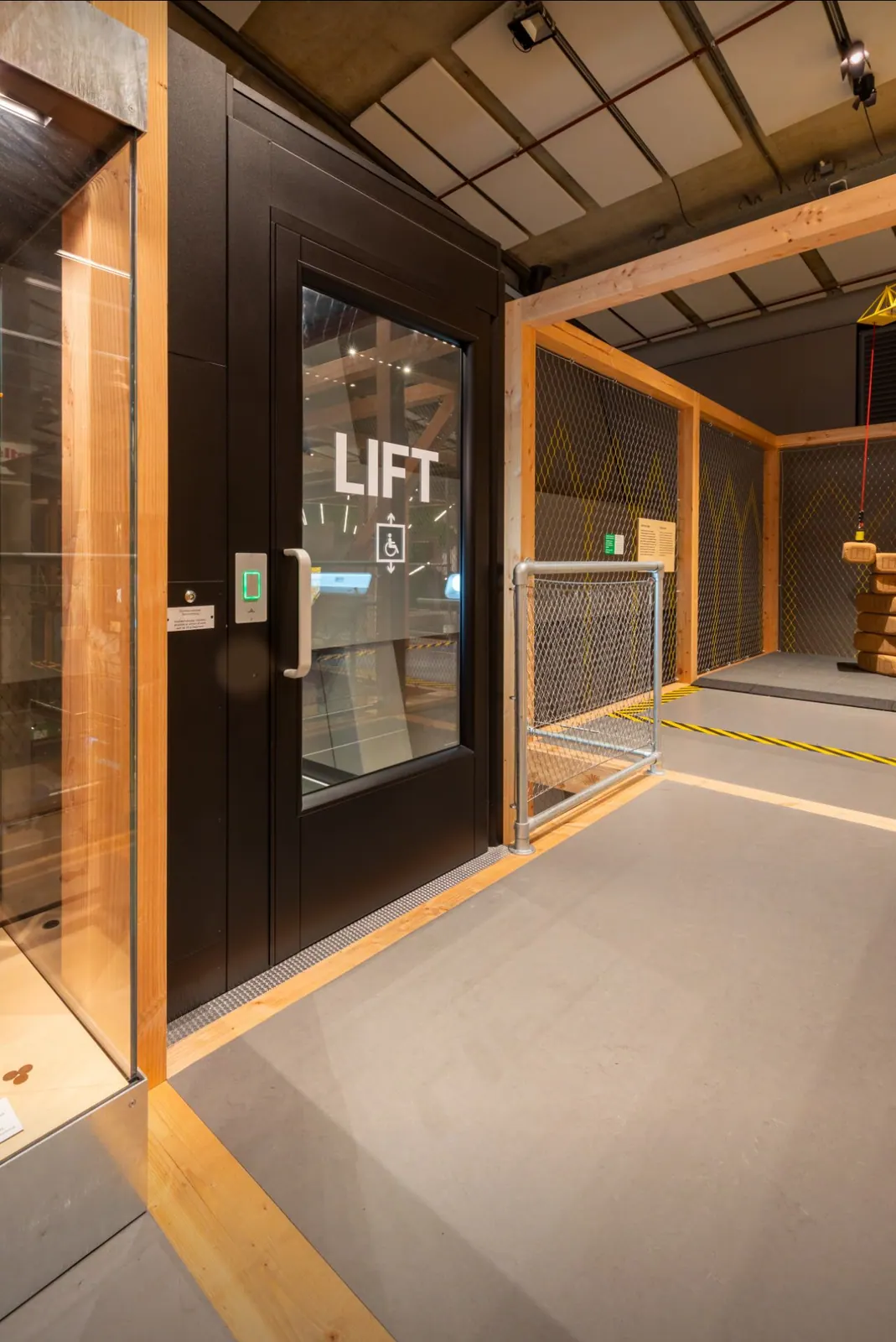 Ascensor Aritco PublicLift Access de cristal y paneles en negro · Local comercial · vista general