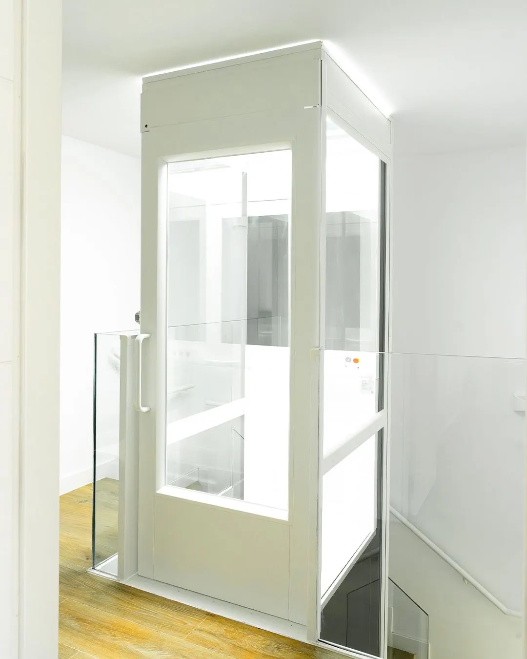 Ascensor Aritco HomeLift Compact de cristal en blanco · Vivienda unifamiliar con escalera de madera en Boadilla del Monte · vista general