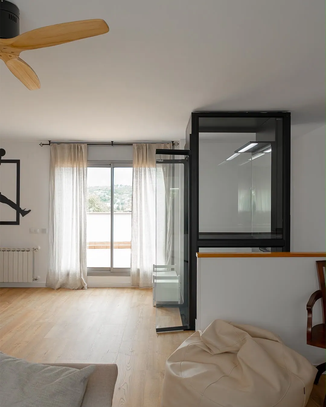 Ascensor Aritco HomeLift Compact de cristal en negro · Vivienda unifamiliar en Sabadell con ascensor junto a la chimenea · vista general