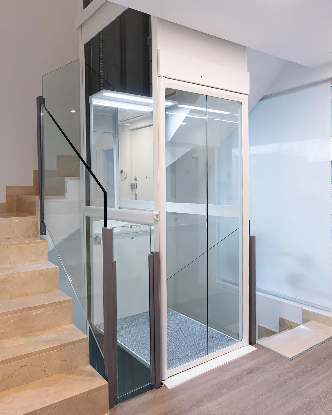 Ascensor Aritco HomeLift Compact de cristal en blanco · Vivienda unifamiliar con escalera de mármol en Boadilla del Monte · vista general