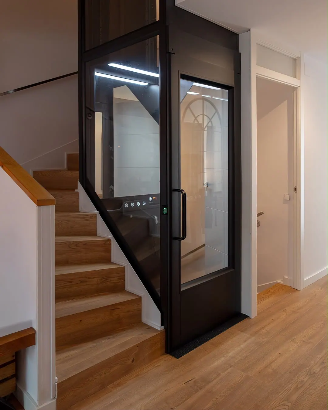 Ascensor Aritco HomeLift Compact de cristal en negro · Vivienda unifamiliar en Sabadell con ascensor junto a la chimenea · vista general