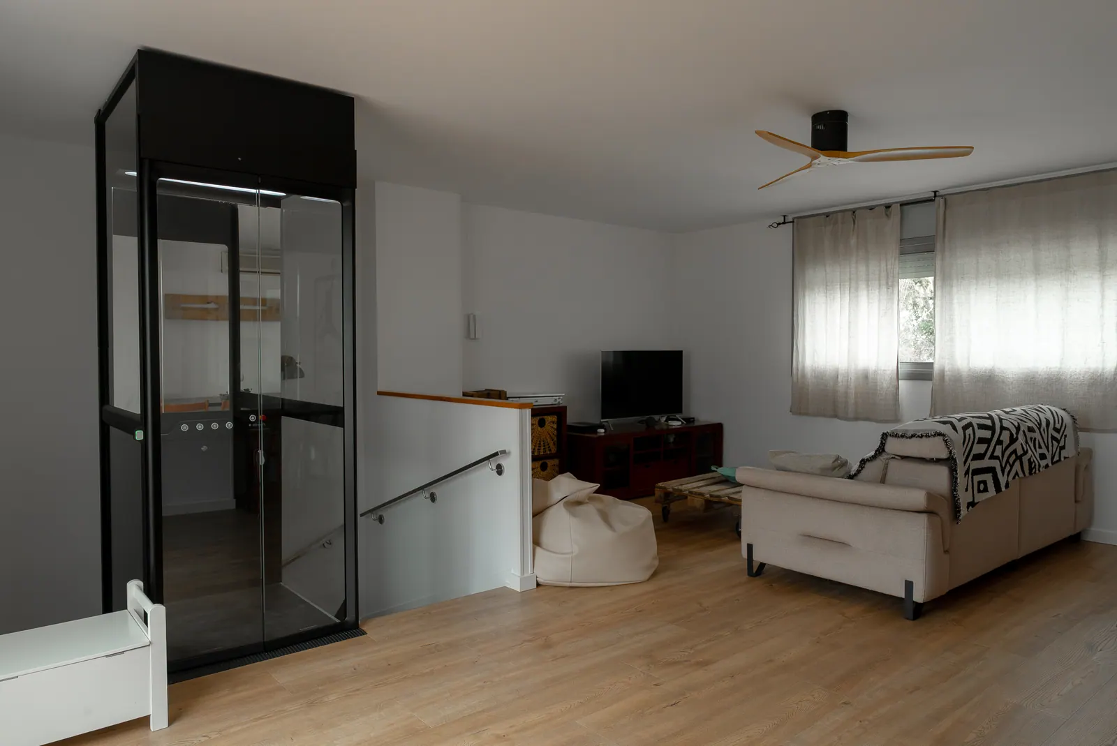 Ascensor Aritco HomeLift Compact de cristal en negro · Vivienda unifamiliar en Sabadell con ascensor junto a la chimenea · vista general