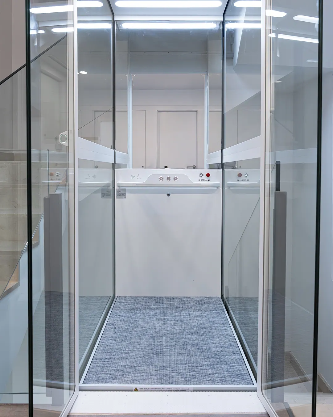 Ascensor Aritco HomeLift Compact de cristal en blanco · Vivienda unifamiliar con escalera de mármol en Boadilla del Monte · interior