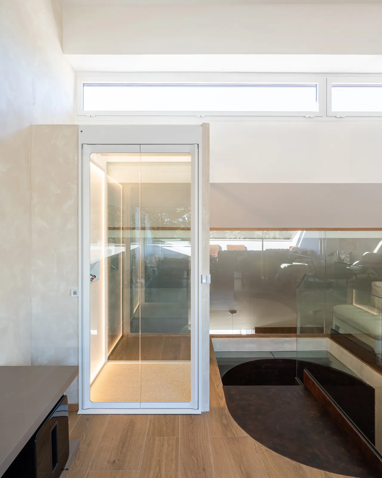 Ascensor Aritco HomeLift de cristal en blanco · Vivienda unifamiliar contemporánea entre piedra y madera · vista general