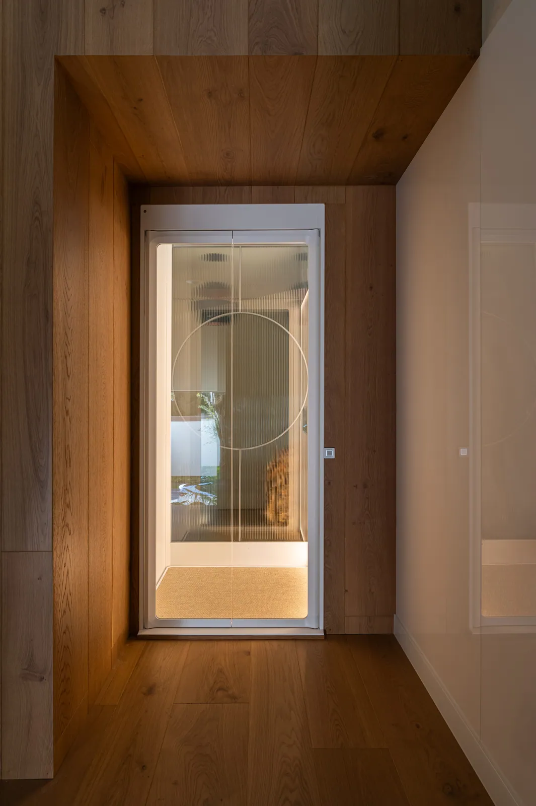 Ascensor Aritco HomeLift de cristal en blanco · Vivienda unifamiliar contemporánea entre piedra y madera · vista general