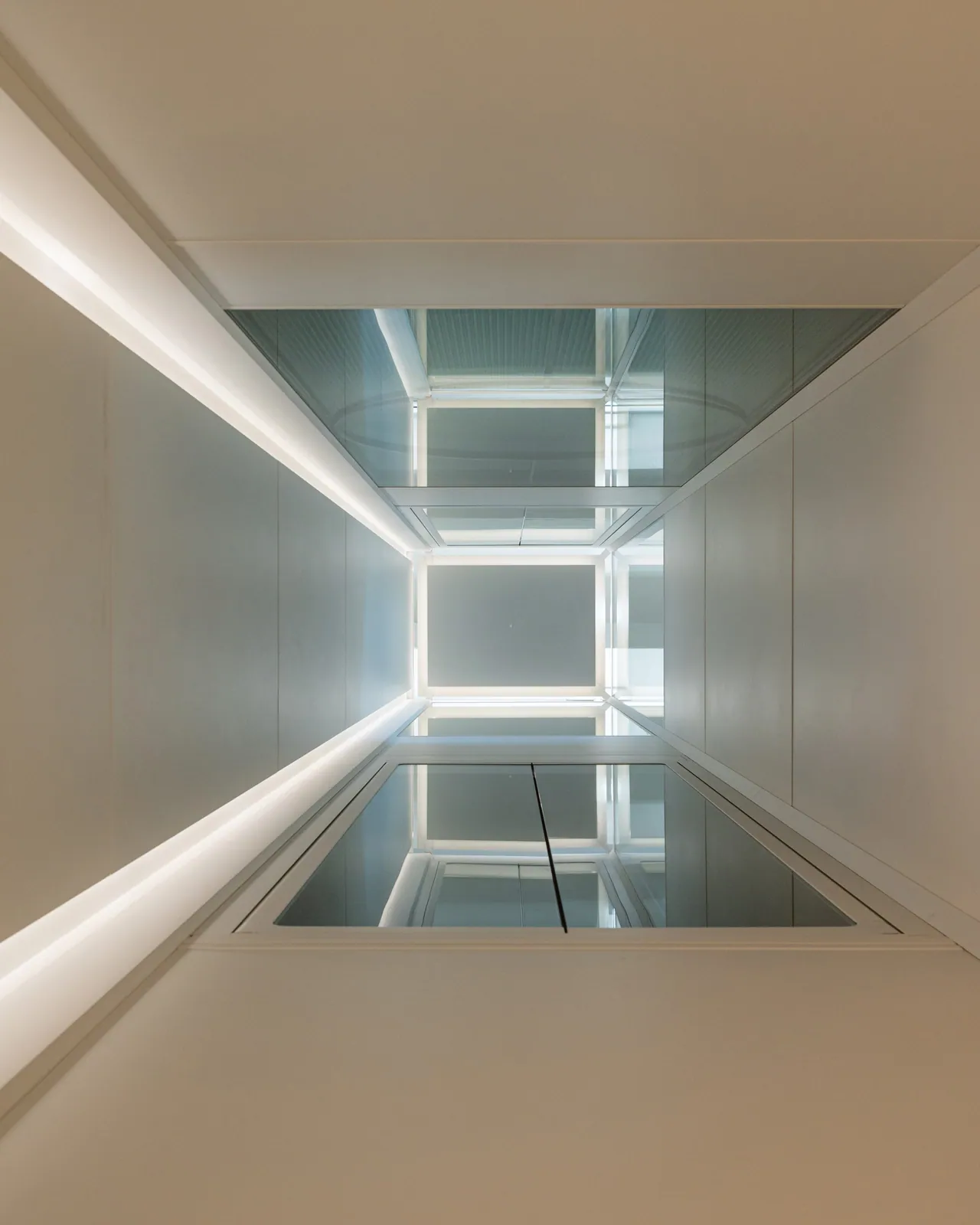 Ascensor Aritco HomeLift de cristal en blanco · Vivienda unifamiliar contemporánea entre piedra y madera · interior