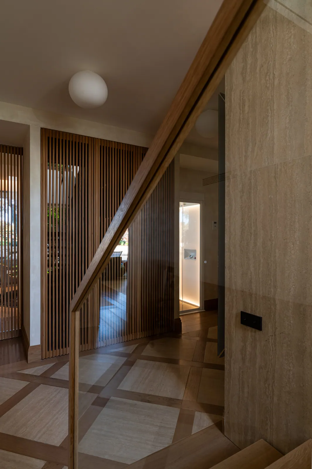 Ascensor Aritco HomeLift de cristal en blanco · Vivienda unifamiliar contemporánea entre piedra y madera · vista general