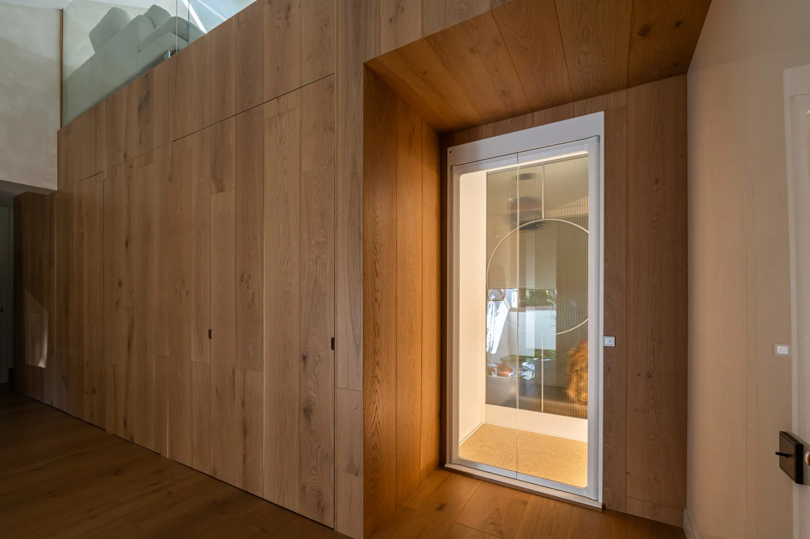 Ascensor Aritco HomeLift de cristal en blanco · Vivienda unifamiliar contemporánea entre piedra y madera · vista general