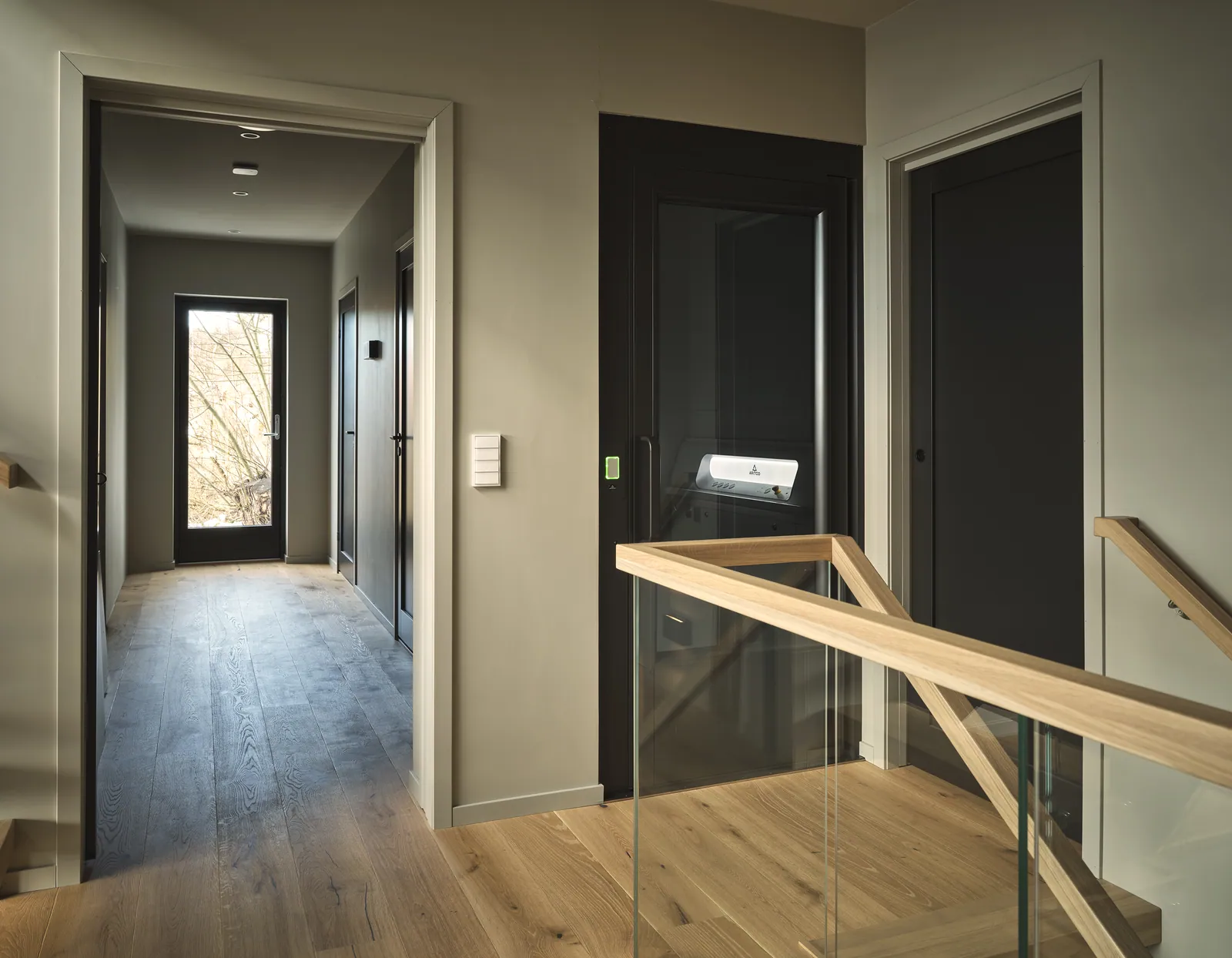 Ascensor Aritco HomeLift Access de paneles opacos en negro · Vivienda unifamiliar contemporánea con suelos de roble · vista general