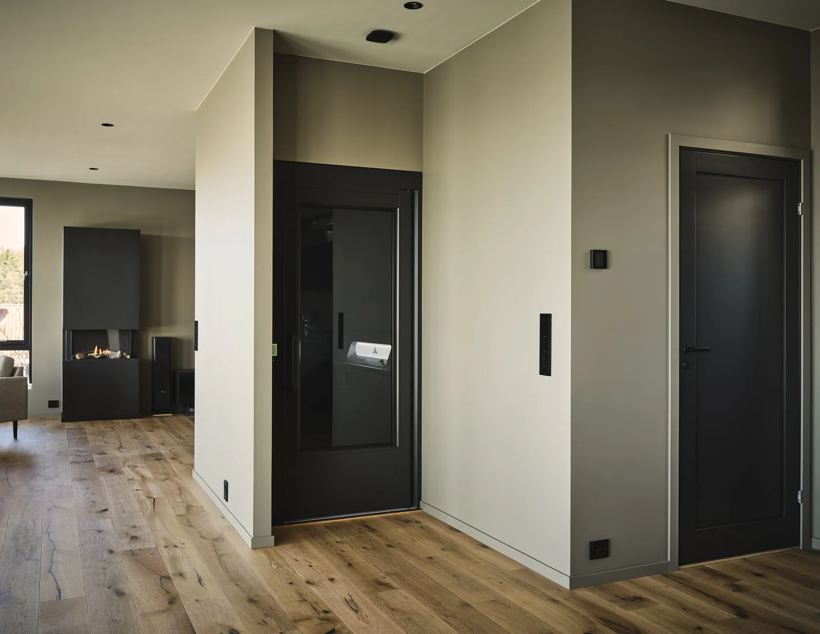 Ascensor Aritco HomeLift Access de paneles opacos en negro · Vivienda unifamiliar contemporánea con suelos de roble · vista general